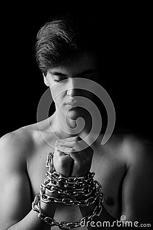 Men locked in metal chain on black background Stock Photo