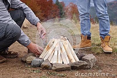 Men making bonfire outdoors, closeup. Camping season Stock Photo