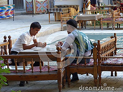 Men playing cards inside a courtyard in Uzbekistan. Editorial Stock Photo