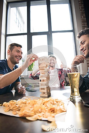 Men playing jenga game Stock Photo