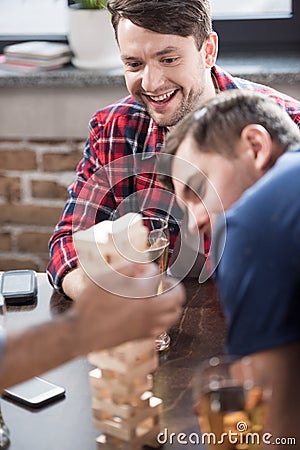 Men playing jenga game Stock Photo