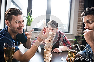 Men playing jenga game Stock Photo