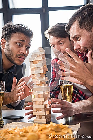 Men playing jenga game Stock Photo