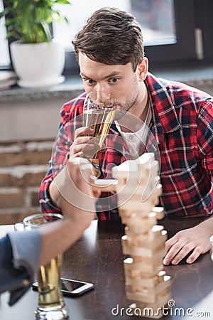 Men playing jenga game Stock Photo