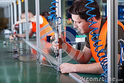 Men during precision work on production line Stock Photo