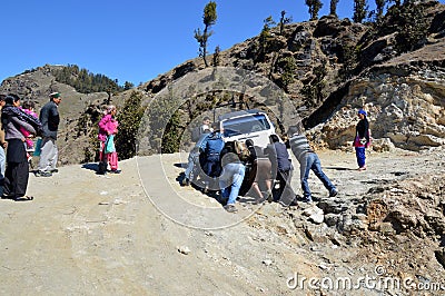 Men pushing a stranded tourist vehicle Editorial Stock Photo