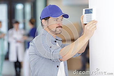 Men regulate temperature on control panel central heating Stock Photo