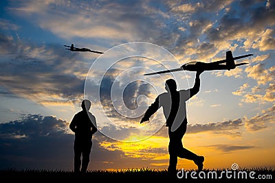Men with remote controlled airplanes at sunset Stock Photo