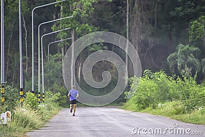 The men are running on the road Background light poles and trees at Kaeng Krachan dam in phetchaburi , Thailand. June 9, 2019 Editorial Stock Photo