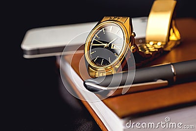Men's accessory, golden watch, pen and mobile phone on the leather diary. Stock Photo