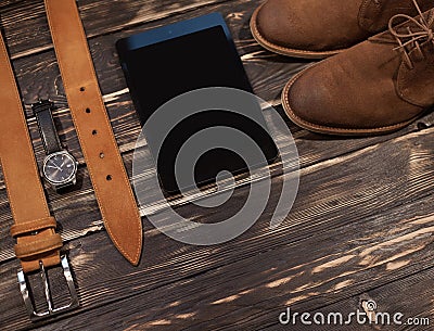 Men`s brown clothing and accessories set: boots, leather belt, watch pc-tablet Stock Photo