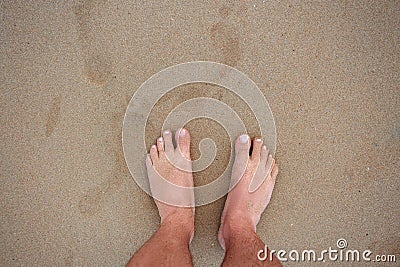 Men`s feet on the sand Stock Photo