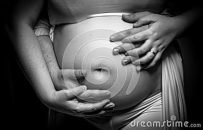 Men`s hands on the belly of a pregnant woman Stock Photo