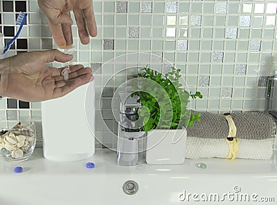 Men`s hands press on the soap dispenser. Stock Photo