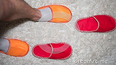 Men`s legs,feet in colorful slippers indoor,top view,slippers on the floor.Home lifestyle. Stock Photo