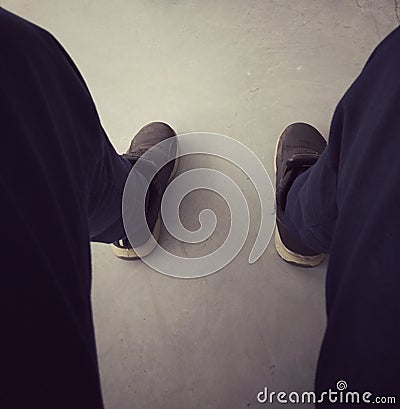 Men`s legs wearing black shoes uniform pants, concept, stress, job loss, warning, fired, anxiety Stock Photo