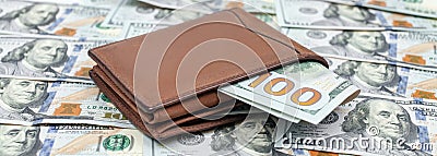 Men`s purse with money. Brown suede wallet with american dollar banknotes lies on one hundred dollar bills Stock Photo