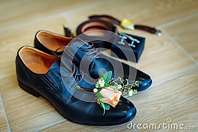 Men`s shoes in black leather, close-up. Wedding concept. Men`s shoes, cufflinks, belt, watch and boutonniere, selective focus Stock Photo