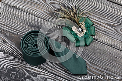 Men`s tie and women`s brooch. Accessories for spouses. Love and Togetherness Objects. On painted boards Stock Photo