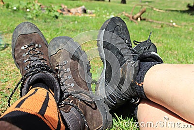 Men`s and women`s trekking shoes on the legs Stock Photo
