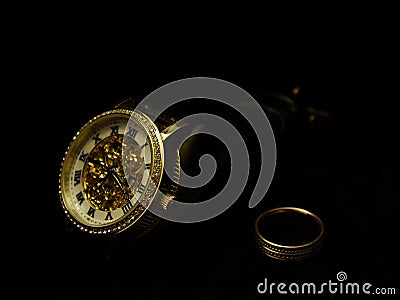 Men`s wristwatch and a ring on a black velvet. Stock Photo