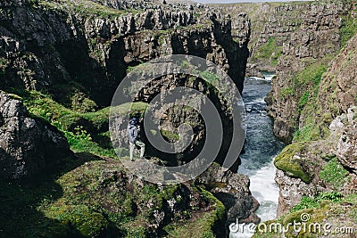 Men stand on edge of cliff at river gorge Stock Photo
