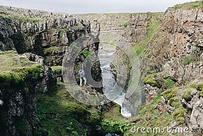 Men stand on edge of cliff at river gorge Stock Photo