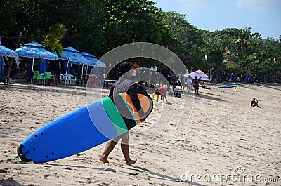Men with surfboards at famous Kuta Beach in Bali Editorial Stock Photo
