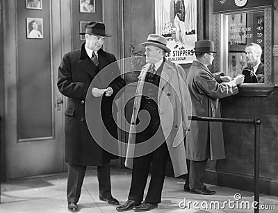 Men talking in theater lobby Stock Photo