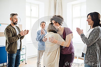 Men and women during group therapy, showing a sign of relief. Stock Photo