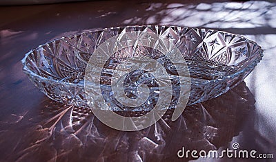 Menazhnitsa - a glass dish with four sections, standing on the table with highlights and reflections Stock Photo