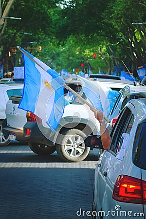 2020-10-12, Mendoza, Argentina: A man holds an argentinian flag from his car during a protest against the national government Editorial Stock Photo