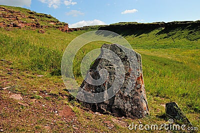 Menhir, tombstone of an ancient burial place near the slope of a high mountain in the summer steppe Stock Photo