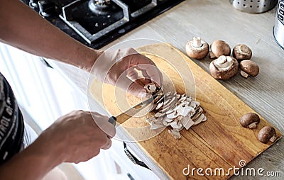 Mens hands cut Fresh mushrooms in kitchen Stock Photo