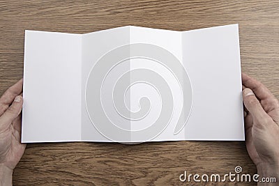 Mens hands holding white booklet Stock Photo