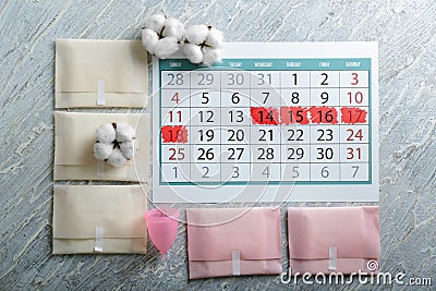 Menstrual calendar with feminine products on light wooden background Stock Photo