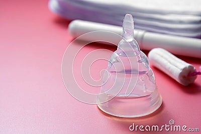 Menstrual cup and feminine hygiene tampon, isolated on pink background. Feminine hygiene products. Copy space Stock Photo