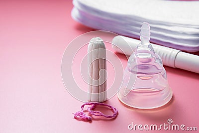 Menstrual cup and feminine hygiene tampon, isolated on pink background. Feminine hygiene products. Copy space Stock Photo