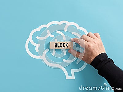 Mental block concept. To remove or generate mental blocks of the human mind. Hand puts a wooden block with the word block on a Stock Photo