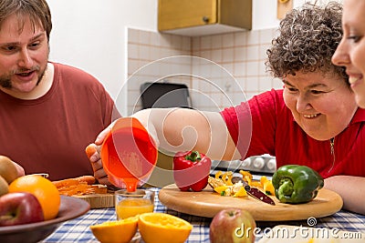 Mentally disabled woman and two caretakers cooking together Stock Photo