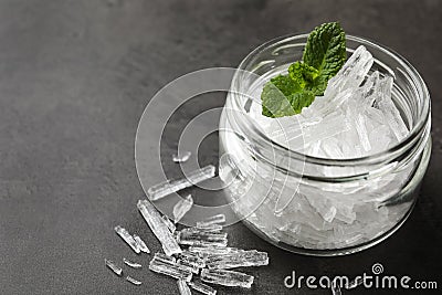 Menthol crystals and mint leaves on grey background, closeup. Space for text Stock Photo