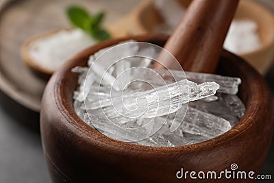 Menthol crystals in wooden mortar, closeup view Stock Photo