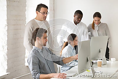 Mentor consulting intern about computer task, helping with onlin Stock Photo