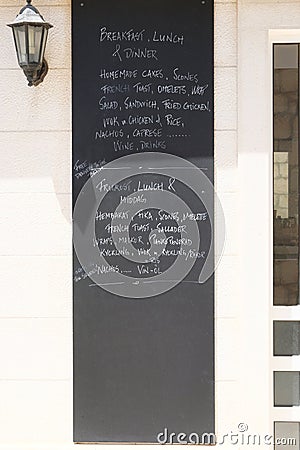 Menu board of cafe or restaurant. Whiteboard with text of menu in an European city. Caption - breakfast, lunch and dinner on Stock Photo