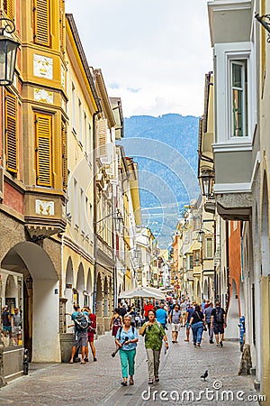 Street scenario of Laubengasse in the main District of Meran with many pedestrians. Merano. South Tyrol, Italy Editorial Stock Photo