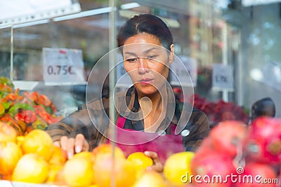 Merchandiser setting out goods in greengrocer Stock Photo