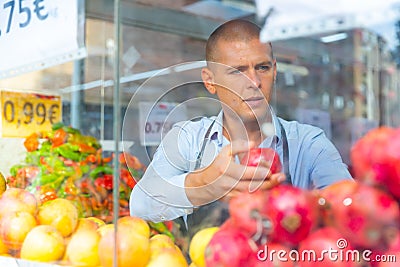 Merchandiser setting out goods in greengrocer Stock Photo