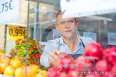 Merchandiser setting out goods in greengrocer Stock Photo