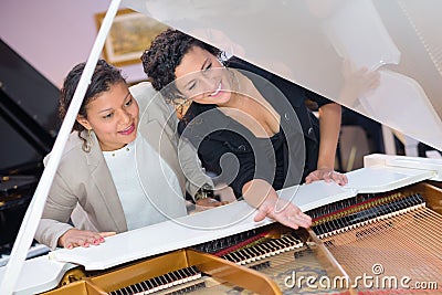 Merchandiser showing grand piano to customer Stock Photo