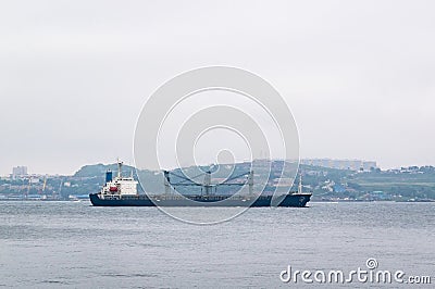 A merchant ship leaves its home port. Stock Photo